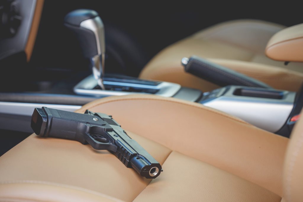 pistola a la vista en el asiento del coche