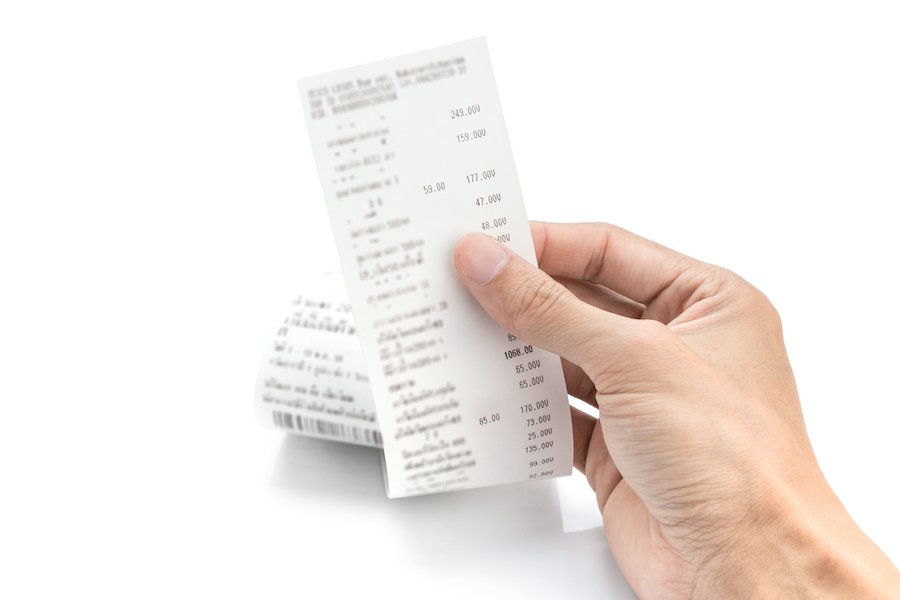Hand holding up sales receipt