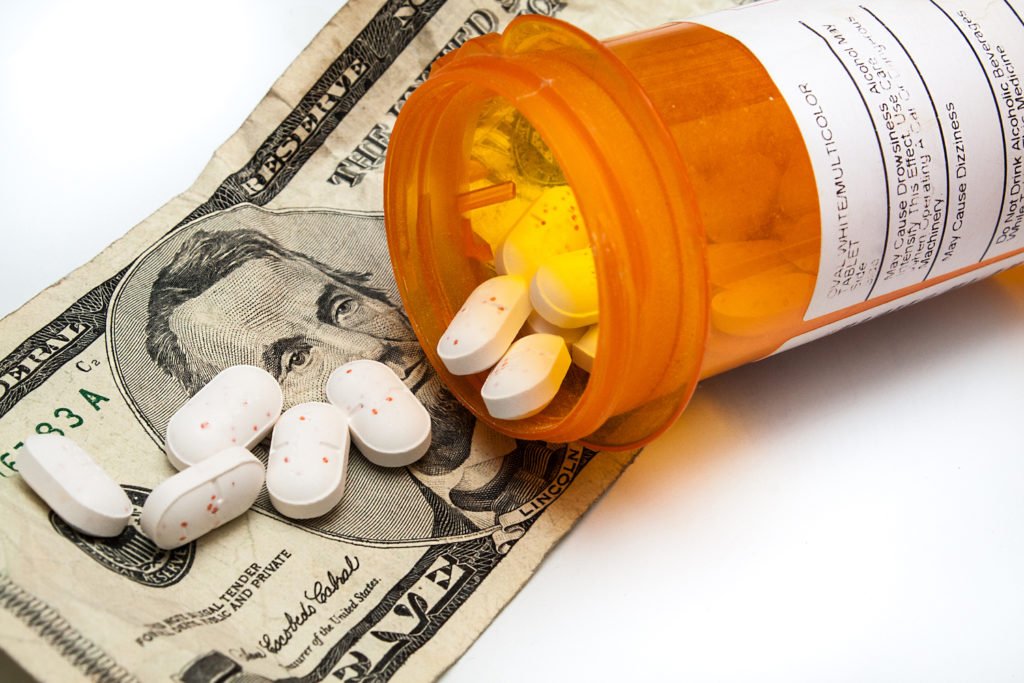 Open pill bottle and cash