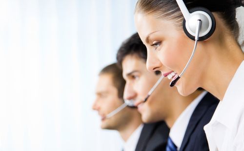Row of three receptionists with headsets on