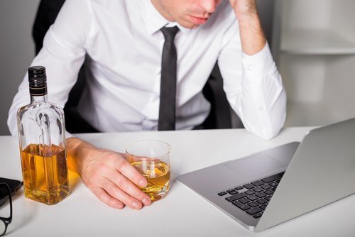 employee at laptop drinking whisky