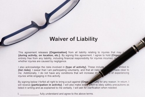 glasses and pen resting on a document titled "Waiver of Liability"