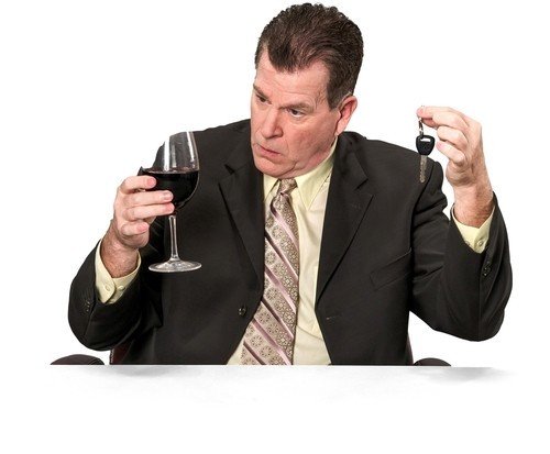 Real estate agent holding glass of wine and holding a car key