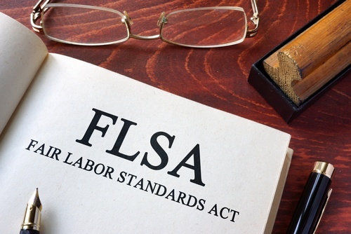 Book with page that reads FLSA - Fair Labor Standards Act