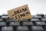 computer keyboard with 'break time' note embedded between keys