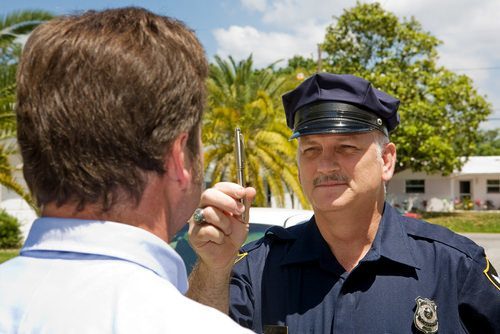 Oficial de policía administrando la prueba de nistagmo horizontal del ojo a un sospechoso de DUI