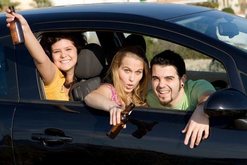 adolescentes bebiendo alcohol en un auto