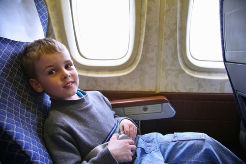 young boy sitting in airplane window seat