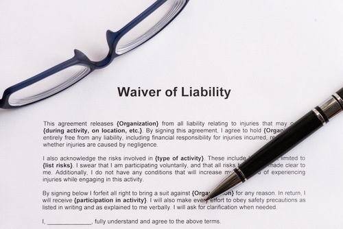 document titled 'waiver of liability' with glasses and pen lying on top of it