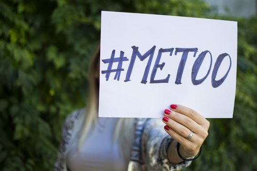 woman's hand holding up sign saying "#MeToo"