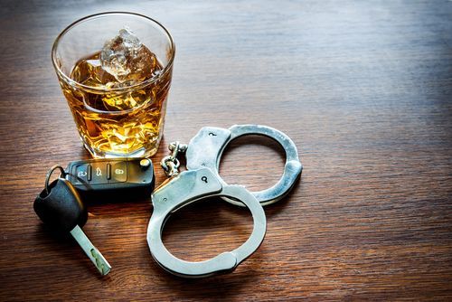 handcuffs, car keys, tumbler of alcohol