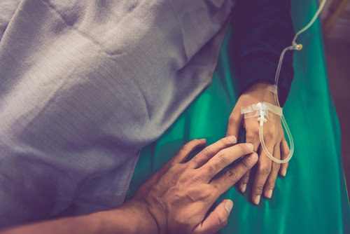 elderly prisoner laying down with IV inserted who may be released early through resentencing