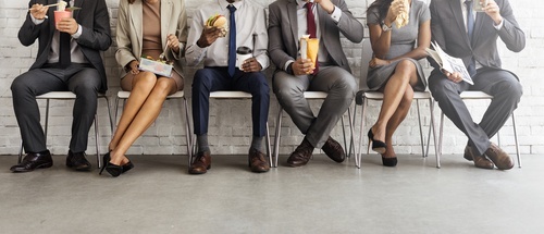 una línea de empleados comiendo almuerzo en sus sillas