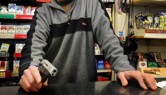 man with gun at cashier about to commit robbery
