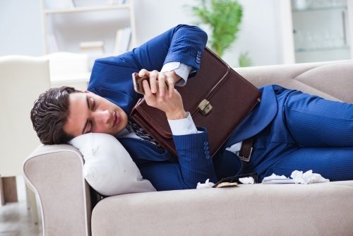 man in suit with briefcase on couch sick