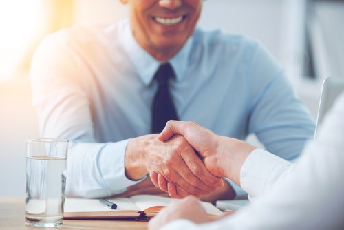 Smiling man in business suit shaking hand of a job applicant