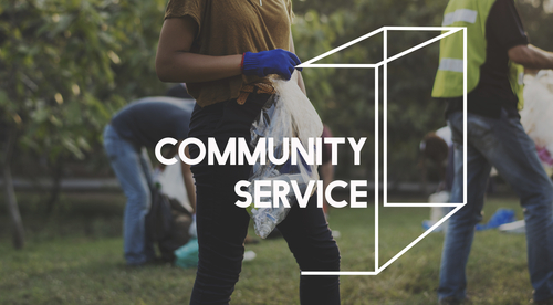 person picking up trash in a park as part of a community service detail