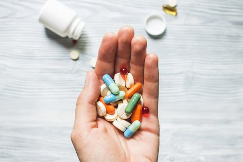 hand holding an assortment of pills