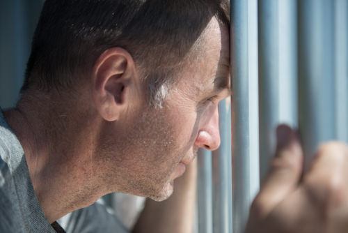 recluso mirando desde una celda de prisión