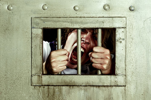 un recluso dentro de una celda de prisión, gritando - El Código Penal 654 PC prohíbe múltiples castigos por el mismo delito
