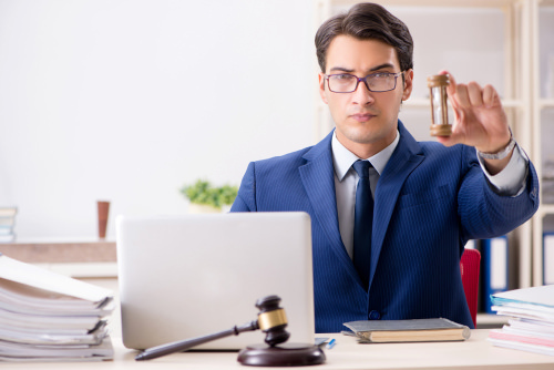 attorney holding an hourglass - criminal defense lawyers have a limited window for pre-file investigations