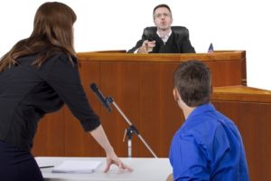 Judge speaking to defense attorney and client in court