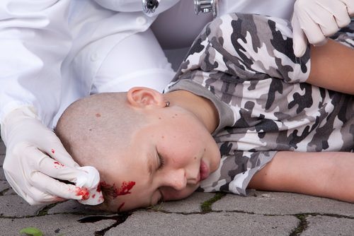 boy passed out on ground with injury to his head