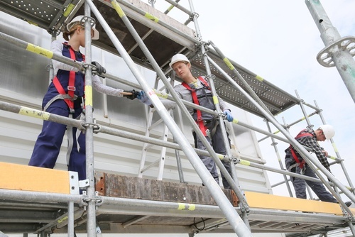 Tres trabajadores de la construcción en un andamio