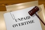 paper that says 'unpaid overtime' and gavel