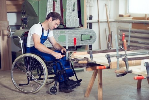 young man in wheelchair sitting in carpentry workshop