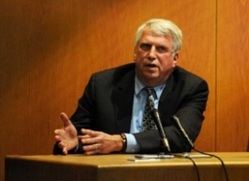 hombre mayor en traje testificando en la corte