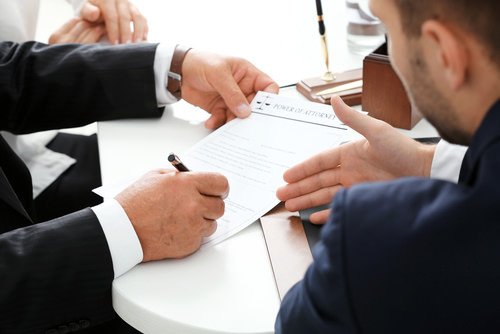 Attorneys at table negotiating over a document