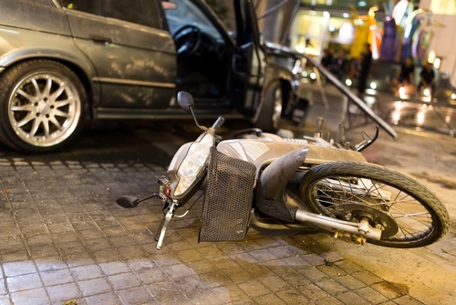 motorcycle on its side after colliding with car