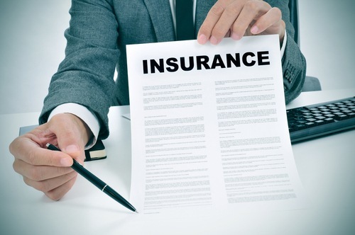 man in suit holding up pen and paper with the title "Insurance"