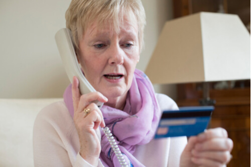 senior citizen holding credit card