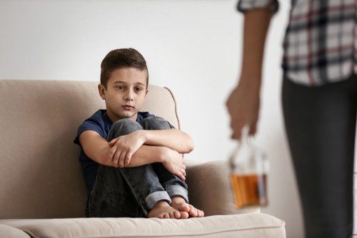 adulto sosteniendo botella de alcohol frente a un niño - el delito de estar intoxicado en presencia de un niño ha sido declarado inconstitucional