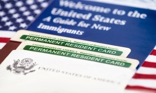 Permanent resident cards on top of a Welcome Guide for New Immigrants