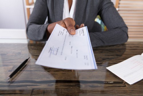 Close-up of boss handing check to employee