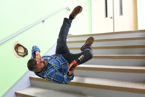 hombre con casco cayendo por una escalera