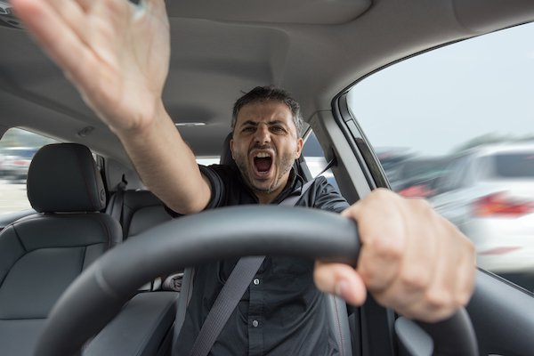 Hombre enojado detrás del volante como ejemplo de conducción agresiva