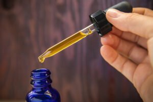Concentrated CBD (cannabinoid) cannabis extract oil against wood background