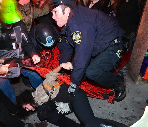 police holding down a protester in what may be a violation of his civil rights