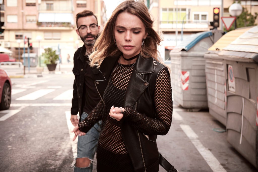 Man pandering a hooker on the street. 