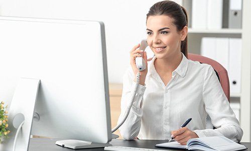 receptionist on telephone behind computer
