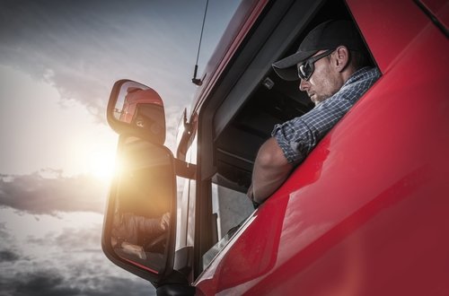 truck driver looking out the window of a big rig - operating an overweight vehicle in California can be a crime under Penal Code 35551a VC