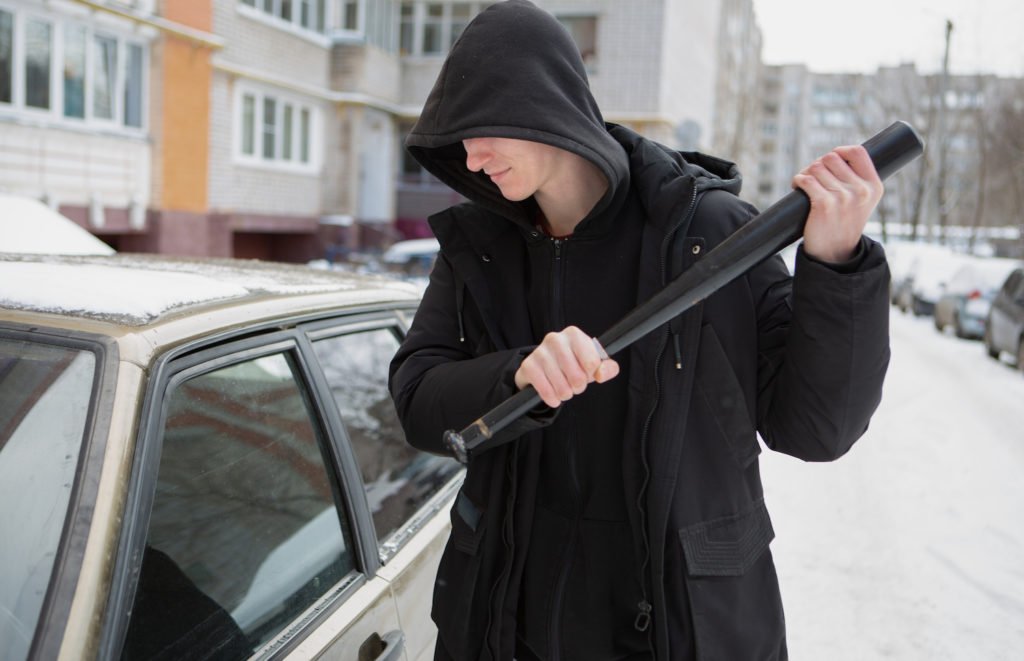 Young man about to vandalize a car in violation of NRS 206.130