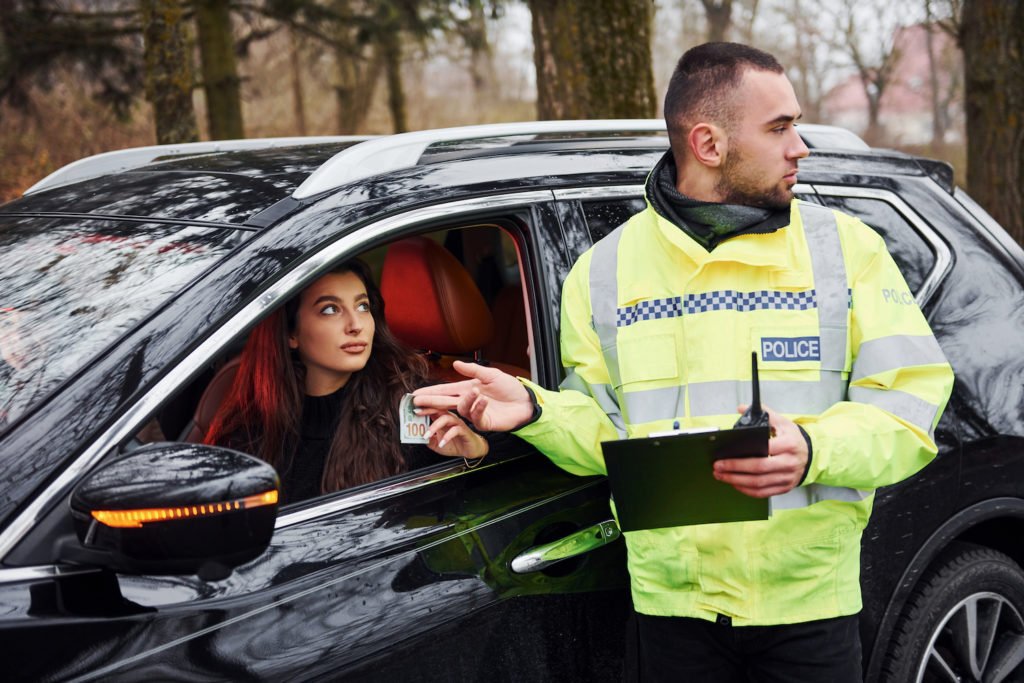 Police officer accepting cash bribe from a pulled-over driver in violation of PC 68