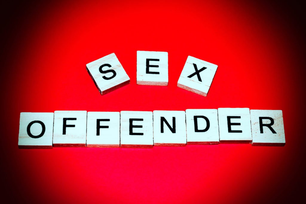 Tiles that spell out "sex offender" in front of a red background
