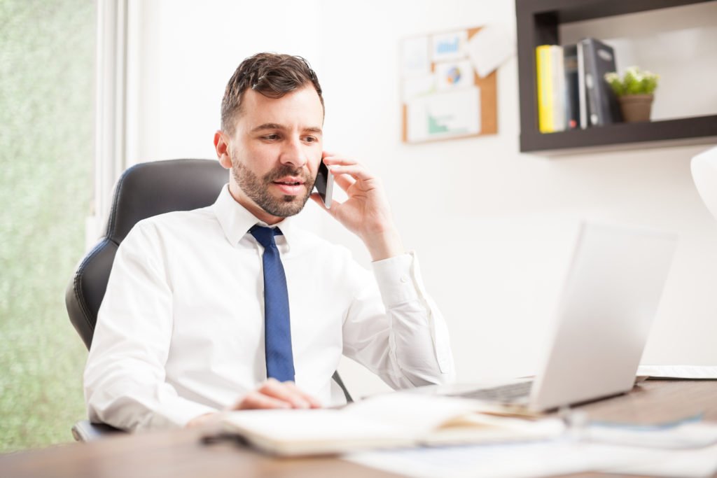 Colorado DUI attorney behind laptop speaking with out-of-state defendant over the phone