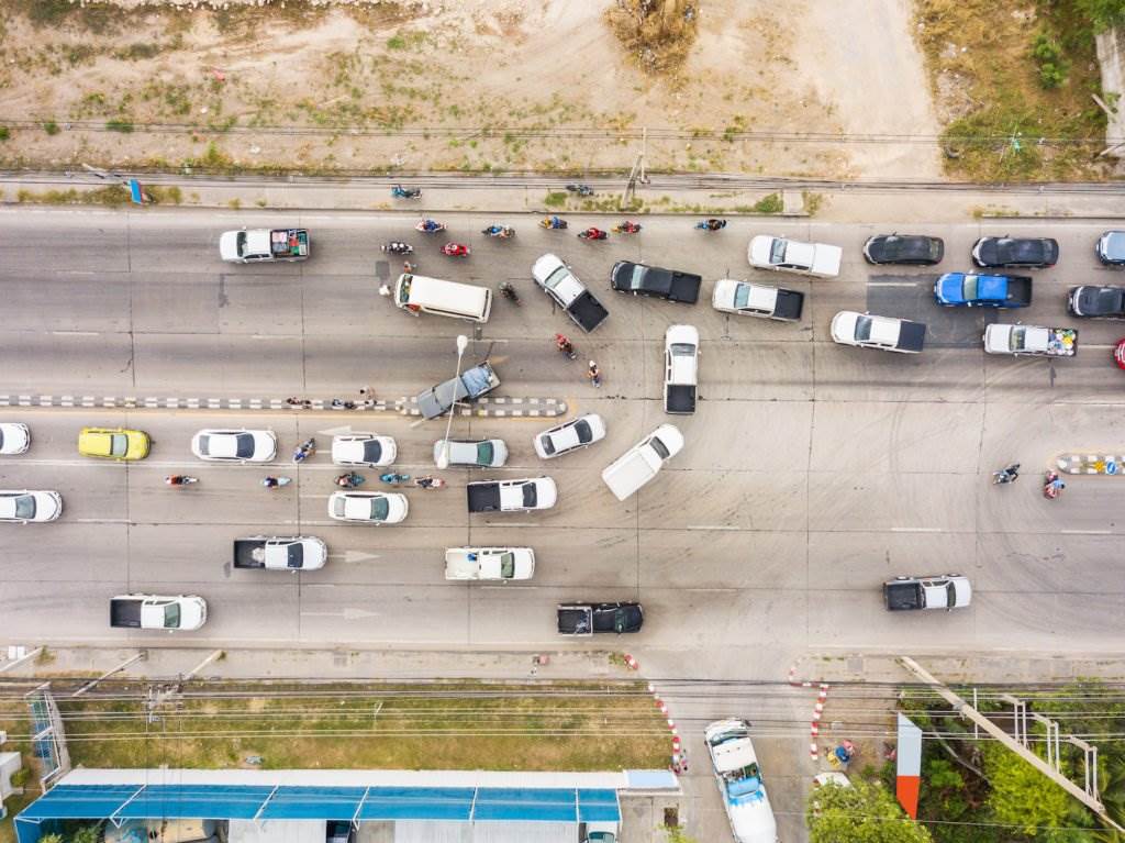Una vista aérea de una calle con vehículos haciendo giros en U y un accidente aparente
